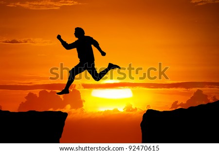 Man jump through the gap between the cliff