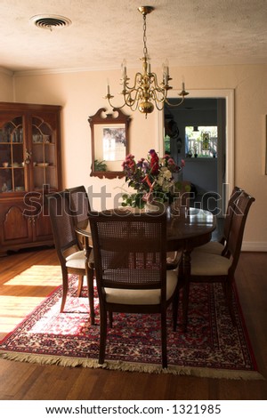 dining room table and chairs with bright sunlight streaming in through large window