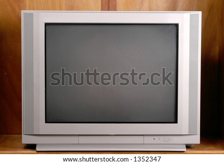 Ordinary and commonplace 27 inch flatscreen television in a wood enclosure cabinet