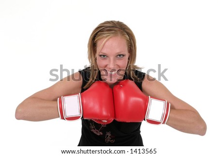 Attractive blonde executive business woman puts on the boxing gloves to do battle in the corporate world.
