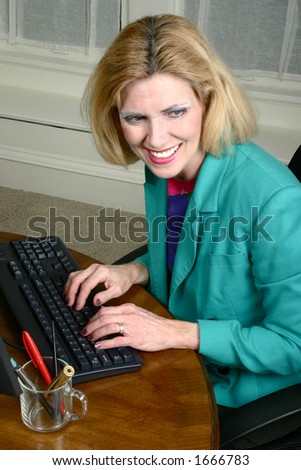 Beautiful business woman laughing with a co-worker neighbor while typing on office computer office.