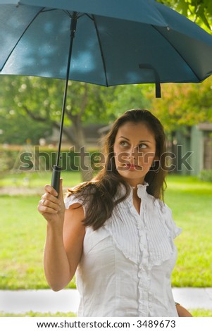 Young beautiful brunette woman holding an umbrella above her head.