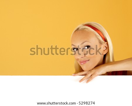 buy this product. Beautiful Young Woman Peeping Over a Banner Over a White Background. good space for writing or placing an image
