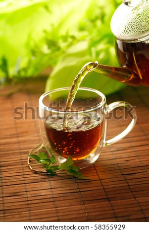 Cup of green tea pouring close up shoot