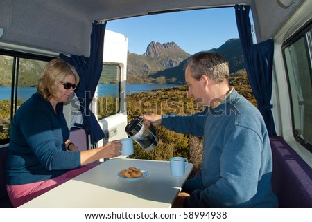 couple having coffee in camper van at Cradle Mountain