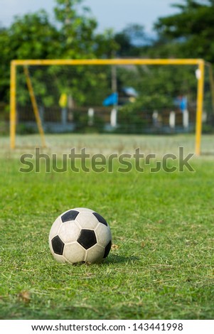 football (soccer) and goal on green field