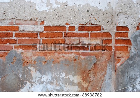 detail of a red bricks wall, with faded gray paint.