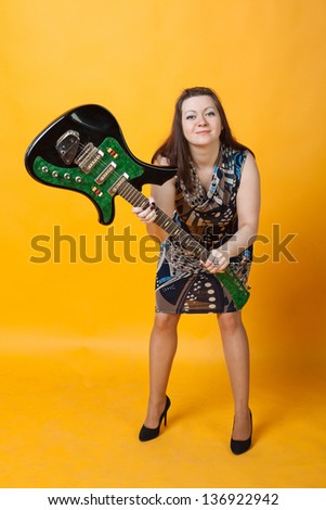 aggressive young woman staying with electric guitar