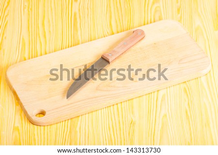 steel knife and Wood chopping board on a table