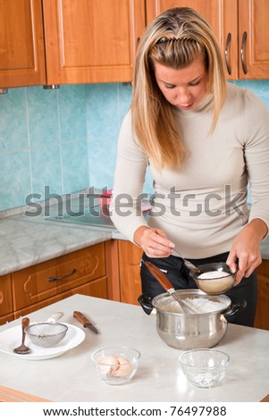 Young woman pours sugar in pot