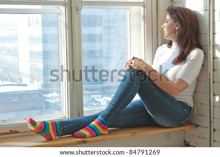 sexy girl sits on a window-sill
