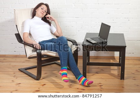 Sexy girl sits  on a armchair and works with notebook