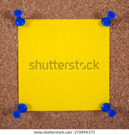 A blank yellow note page pinned to a noticeboard.