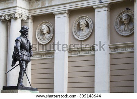 Statue of Sir Walter Raleigh with busts of famous Royal Navy figures in the background.