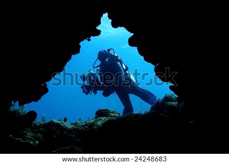 Underwater photographer entering cave system