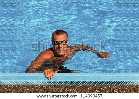 Athletic swimmer posing in a swimming pool