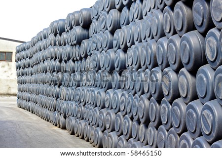Big wall of gray plastic barrels in factory