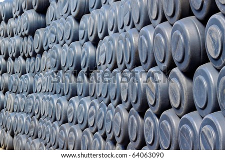Big wall of gray plastic barrels in factory