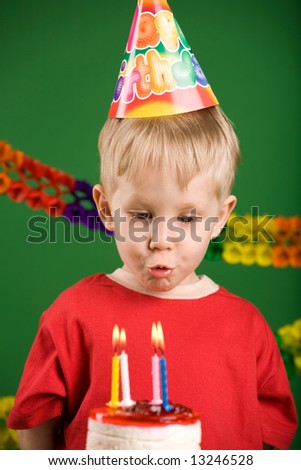 A boy trying to blow the candles on birthday cake