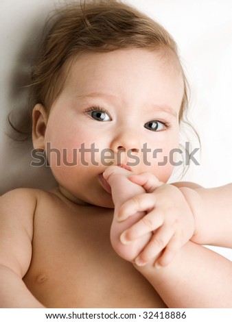 A photo of baby taking his feet in his mouth