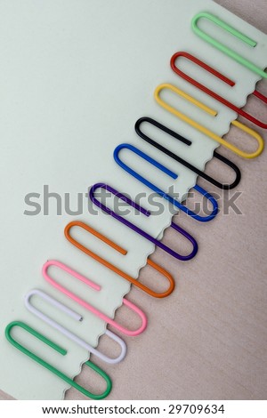 Colorful paper clips and note on a board