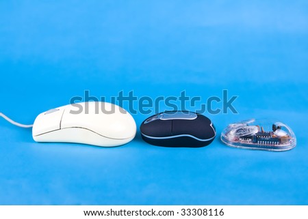 three computer mouses resting on the blue background