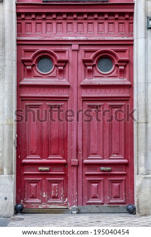 Old fashioned front door entrance, grey facade and red door, Paris