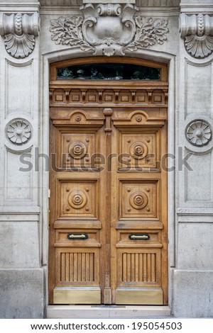 Old fashioned front door entrance, grey facade and brown door, Paris