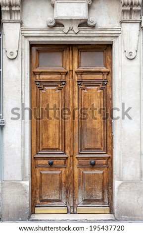 Old fashioned front door entrance, grey facade and brown door, Paris