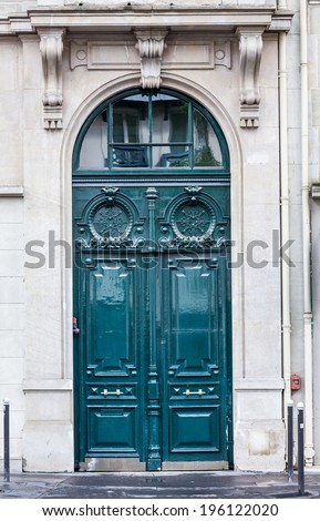Old fashioned front door entrance, grey facade and green door, Paris