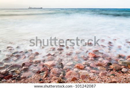 cobble stone beach of Red Sea on sunset, Jordan