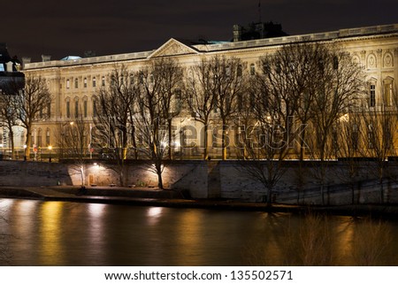PARIS, FRANCE - MARCH 7: Louvre Palace from quay at night. The museum is housed in the Louvre Palace which began as a fortress built in the late 12th century in Paris, France on March 7, 2013