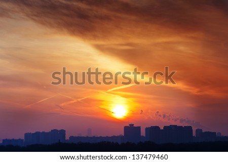 orange early rising sun under city