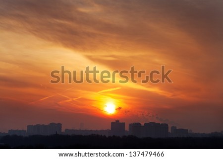 dark orange early rising sun under city