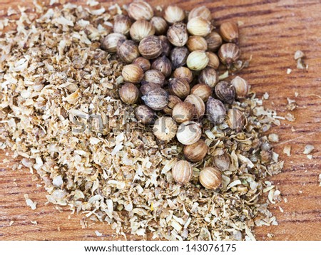 freshly ground coriander and dried coriander seeds on wooden board