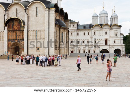MOSCOW, RUSSIA - JULY 12: tourists on Sobornaya square near Dormition cathedral in Moscow Kremlin, Russia on July 12, 2013. In its present form cathedral was constructed between 1475Ã?Â¢??79