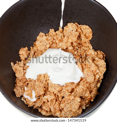 top view of yoghurt is poured into bowl of cereal