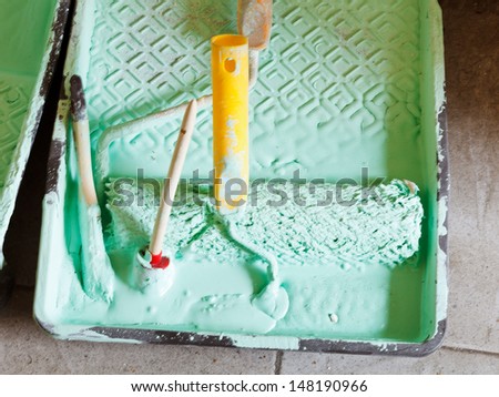 plastic paint tray with paint brushes and paint roller