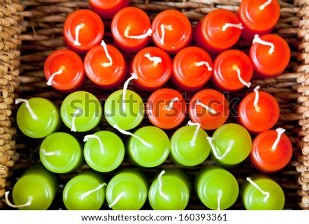 top view of red and green candles in woven basket