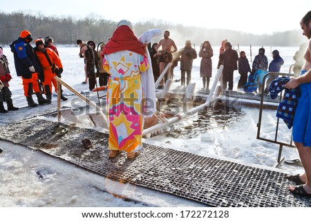 MOSCOW, RUSSIA - JANUARY 19, 2014: people near ice hole in frozen Akademicheskiy pond and traditional ice swimming in Orthodox church Holy Epiphany Day