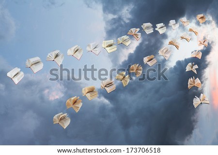 flock of flying books with storm clouds background
