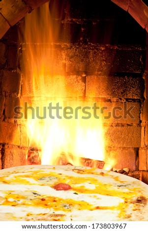 italian pizza and fire flames in wood burning oven