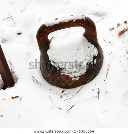 old weight in backyard under the snow in winter day