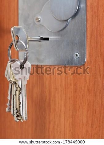 bunch of home keys in keyhole of wooden door
