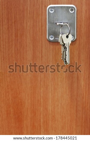 several keys in keyhole of wooden door