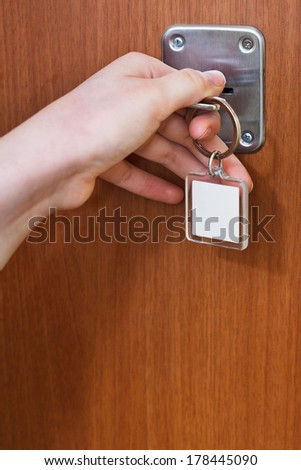 closing home door by key with blank keychain close up