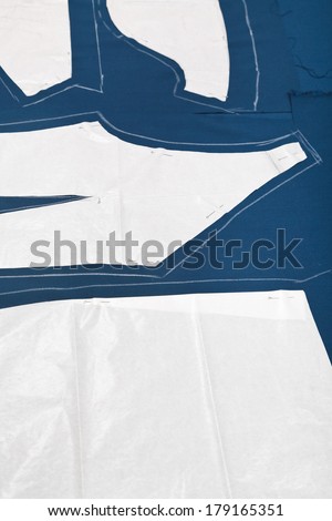 pattern and paper model of clothes on blue fabric for dress cutting
