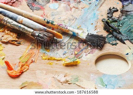 old paintbrushes on wooden used oils artistic pallette