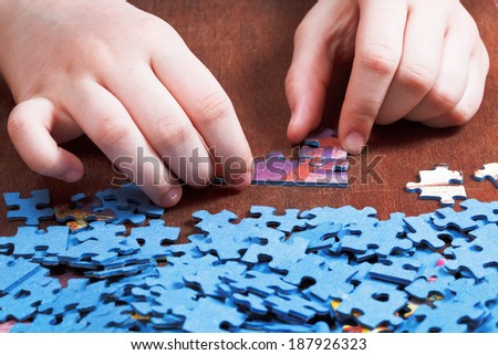 attaching of jigsaw puzzles on wooden table