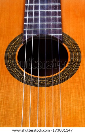 sound hole of classical acoustic guitar with six nylon strings close up